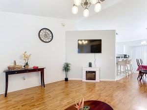 ein Wohnzimmer mit einem Tisch und einer Uhr an der Wand in der Unterkunft Gulf Coast Home 3BR2BA for 8 in North Port