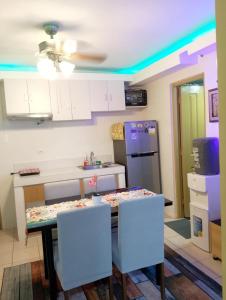een keuken met een tafel met stoelen en een koelkast bij Viv's condotel @ centro spatial in Davao City