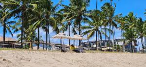 een persoon die op een strand zit met parasols bij Beach Class Verano Muro Alto in Porto De Galinhas