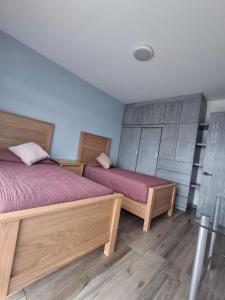 two beds in a room with wooden floors at Cielito Lindo in Uruapan del Progreso