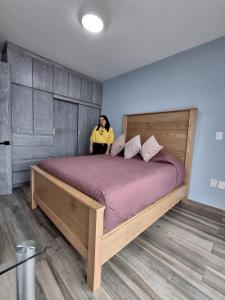 a woman sitting on a large bed in a room at Cielito Lindo in Uruapan del Progreso