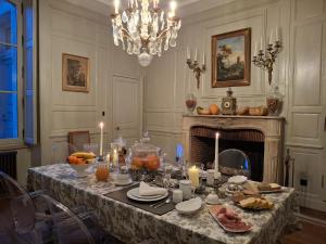een eetkamer met een tafel met eten en kaarsen bij Hôtel Savare in Blois