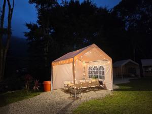 a white tent with chairs in a yard at night at 苗栗南庄 春友彩虹民宿SpringYU in Nanzhuang
