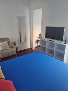 een woonkamer met een tv en een bank bij Casa da Bisa Ubatuba in Ubatuba