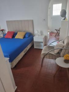 een slaapkamer met een blauw bed en een bank bij Casa da Bisa Ubatuba in Ubatuba