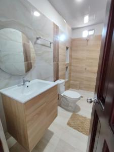een badkamer met een wastafel, een toilet en een spiegel bij Hotel Kelly Mar in Tolú +53 foto's