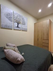 een slaapkamer met een bed met drie schilderijen aan de muur bij Monarca in Uruapan del Progreso