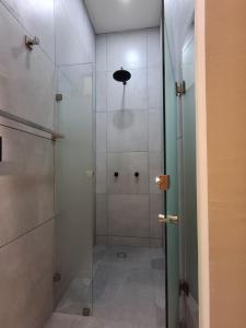 een douche met een glazen deur in een badkamer bij Monarca in Uruapan del Progreso