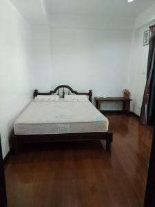 a bed in a room with a wooden floor at Montana Home in Ban Pok Nai