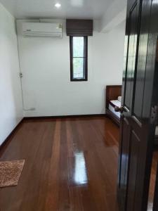 an empty room with a wooden floor and a window at Montana Home in Ban Pok Nai