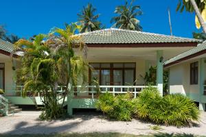 a house with a porch and palm trees at Green Heaven Bungalows in Ban Bang Po