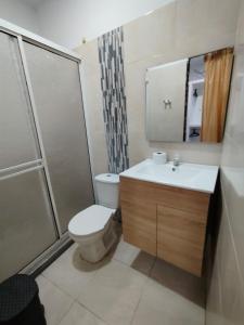 een badkamer met een toilet, een wastafel en een douche bij Hotel Kelly Mar in Tolú