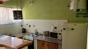 a kitchen with a refrigerator and a stove and a microwave at Rocio de Luna in Villa Ventana