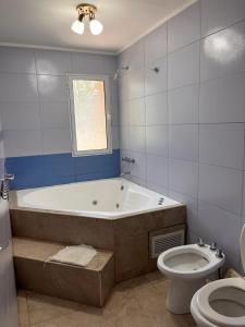 a bathroom with a bath tub and a toilet at Rocio de Luna in Villa Ventana
