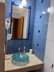 a blue bathroom with a sink and a mirror at Rocio de Luna in Villa Ventana