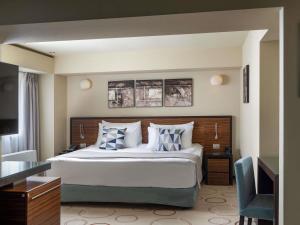 een slaapkamer met een groot bed en een televisie bij Bucharest Unirii Square - Handwritten Collection in Boekarest +166 foto's