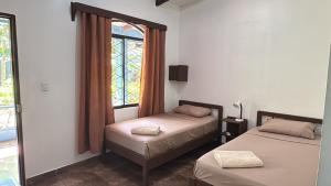 En eller flere senge i et værelse på Hotel Marielos