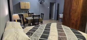 een slaapkamer met een bed, een tafel en stoelen bij Yoruville in Rustenburg