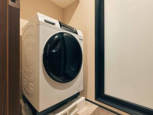 a washing machine sitting in a room next to a door at illi Noa Hamamatsucho in Tokyo