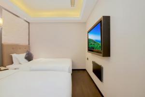 a bedroom with a bed and a tv on a wall at WangfujingXiyuanHotel Central Beijing in Beijing +28 photos