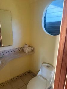 een badkamer met een toilet, een wastafel en een spiegel bij LaCusuca in Guadalajara