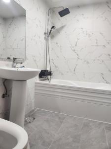 un bagno bianco con lavandino e vasca di Busan Station Centum Hotel a Busan