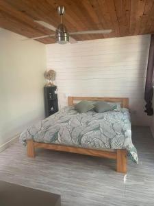 una camera con letto in una stanza con soffitto di Bungalow à Dumbea rivière 