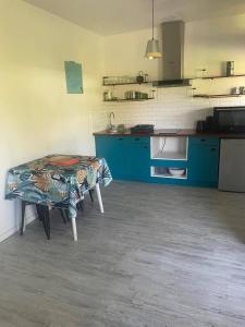 una cucina con armadi blu e tavolo di Bungalow à Dumbea rivière 