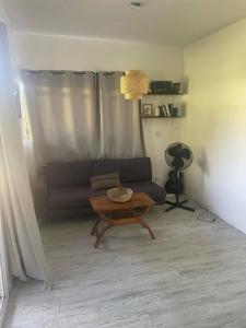 un soggiorno con un divano e un tavolino da caffè di Bungalow à Dumbea rivière 