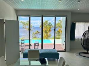 a bedroom with a bed and a view of the ocean at YUTO Ishigakijima in Ishigaki Island