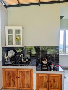 a kitchen with wooden cabinets and a counter top at Fatmara Villa Full House in Kejajar