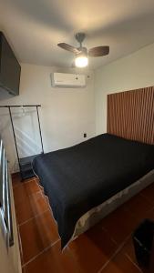 een slaapkamer met een zwart bed en een plafondventilator bij Hogar Kada in Tepic