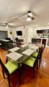 een eetkamer met een glazen tafel en stoelen bij Hogar Kada in Tepic