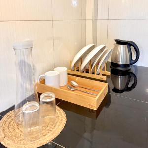 a wooden tray with cups and a vase on a table at Brisa Room T in El Nido Airport