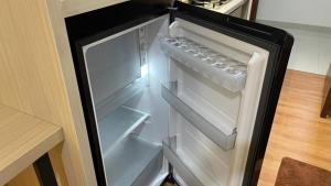 an empty refrigerator with its door open in a kitchen at Dewi's Pollux in Batam Center