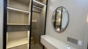 a bathroom with a mirror and a walk in closet at Dewi's Pollux in Batam Center