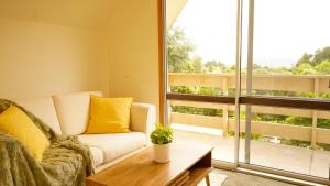 een woonkamer met een bank en een groot raam bij Ora Springs Retreat  +62 foto's