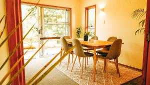 een eetkamer met een houten tafel en stoelen bij Ora Springs Retreat 