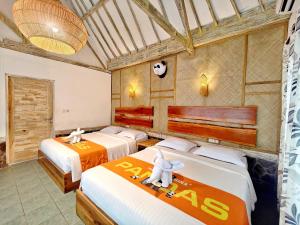 een slaapkamer met 3 bedden in een kamer bij Panda Home in Gili Trawangan
