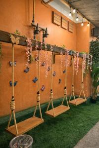 una fila di altalene allineate contro un muro con farfalle di Shalom Center chaweng Samui a Chaweng Beach