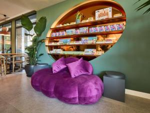 a purple bean bag chair in front of a store at Ibis Styles Madrid Airport Valdebebas in Madrid