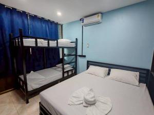 a room with two bunk beds with a hat on it at Dee-maak Hostel in Thongsala