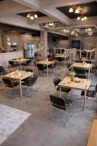 un ristorante con tavoli e sedie in legno in una stanza di Shalom Center chaweng Samui a Chaweng Beach
