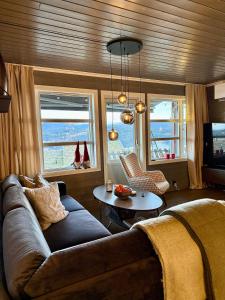 a living room with a couch and a table at Unique view! Modern apartment with sauna in Vossevangen