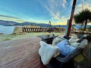 a wicker chair sitting on a deck with a table at Unique view! Modern apartment with sauna in Vossevangen