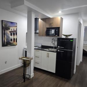 een keuken met een zwarte koelkast en een spoelbak bij Ici Chez Vous in Trois-Rivières +25 foto's