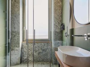 a bathroom with a glass shower stall and a sink at Hotel Giacomo Morra Alba - Handwritten Collection in Alba