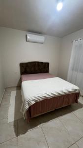 een slaapkamer met een groot bed in een kamer bij Jardim dos Ipês in Araranguá