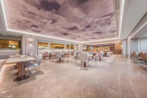 a restaurant with tables and chairs in a room at Mercure Beijing Future Science City in Beijing