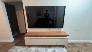 een tv op een dressoir in een kamer bij Jardim dos Ipês in Araranguá